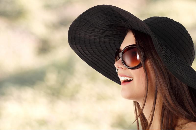 Woman wearing black hat and sunglasses.