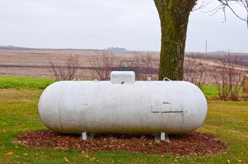 A propane tank is installed in a big back yard.